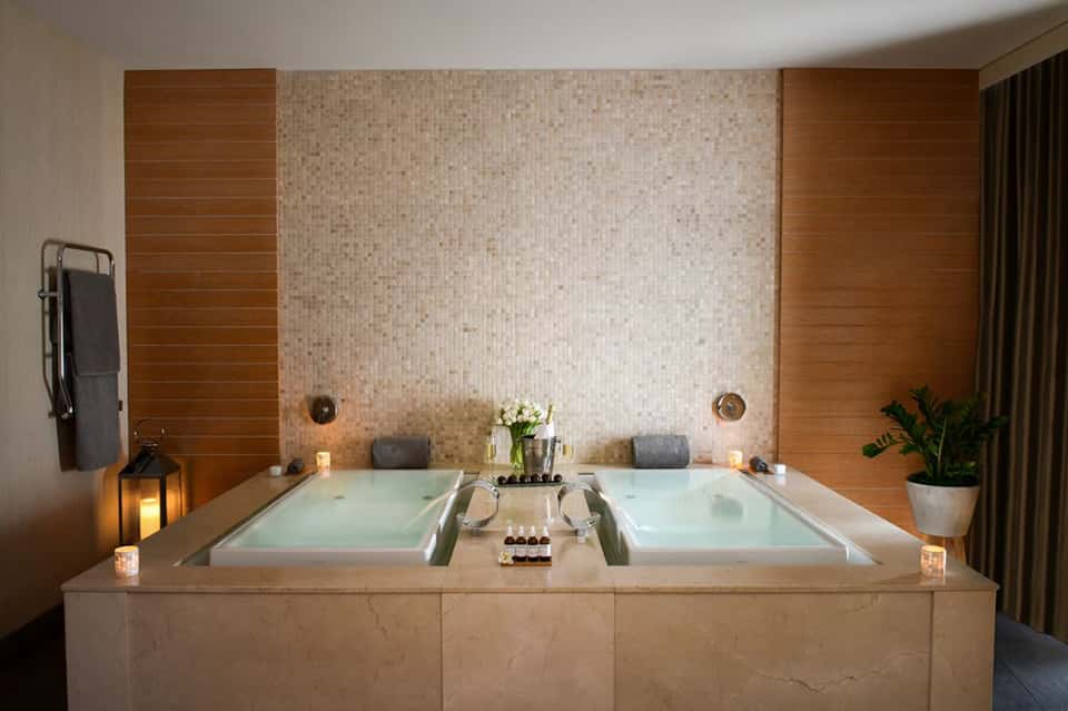 Luxury spa bathroom featuring dual soaking tub with marble surround and mood lighting