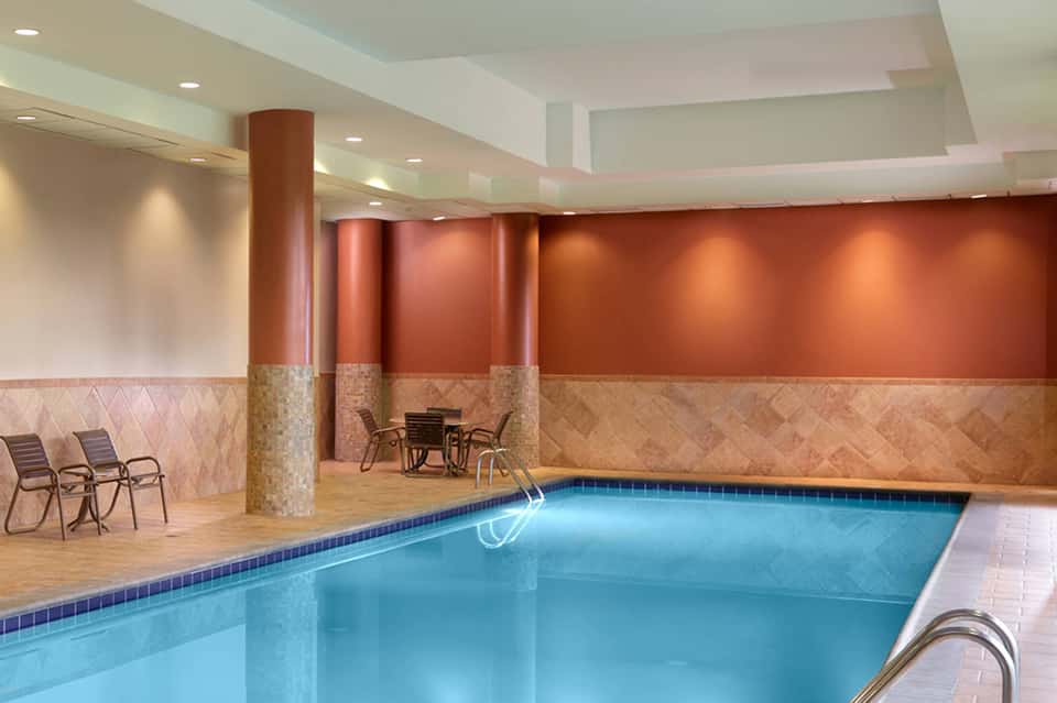 Indoor saltwater pool with terra cotta walls, support columns, and lounge seating area