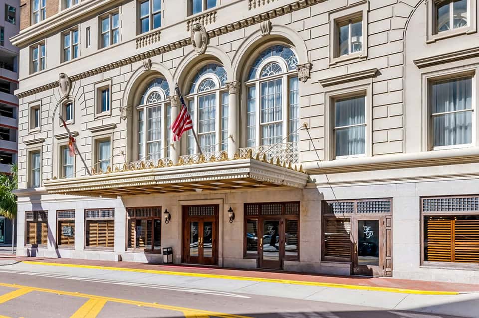 Historic ornate building facade with arched windows, gold trim, and American flag above entrance