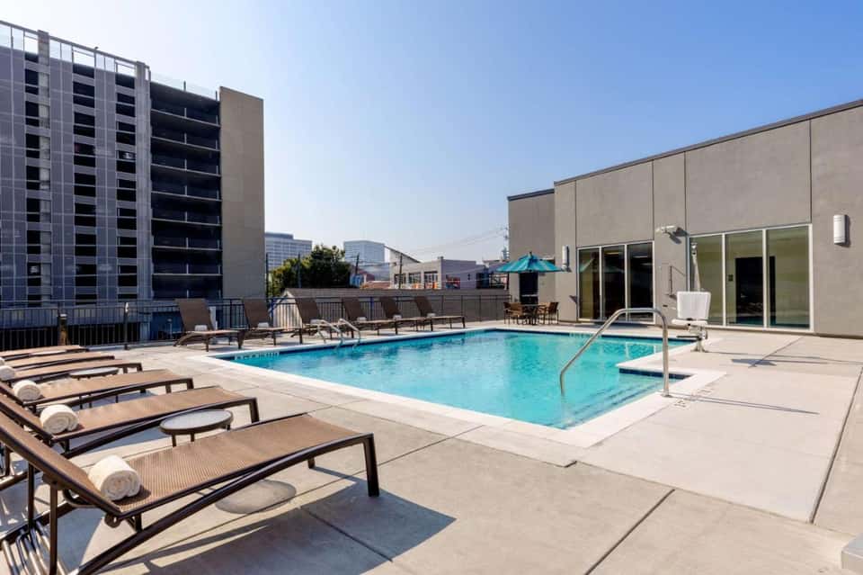 Rooftop pool at urban high-rise hotel with lounge chairs and city views