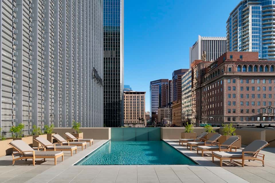 Urban rooftop pool overlooking downtown skyline with modern high-rise buildings