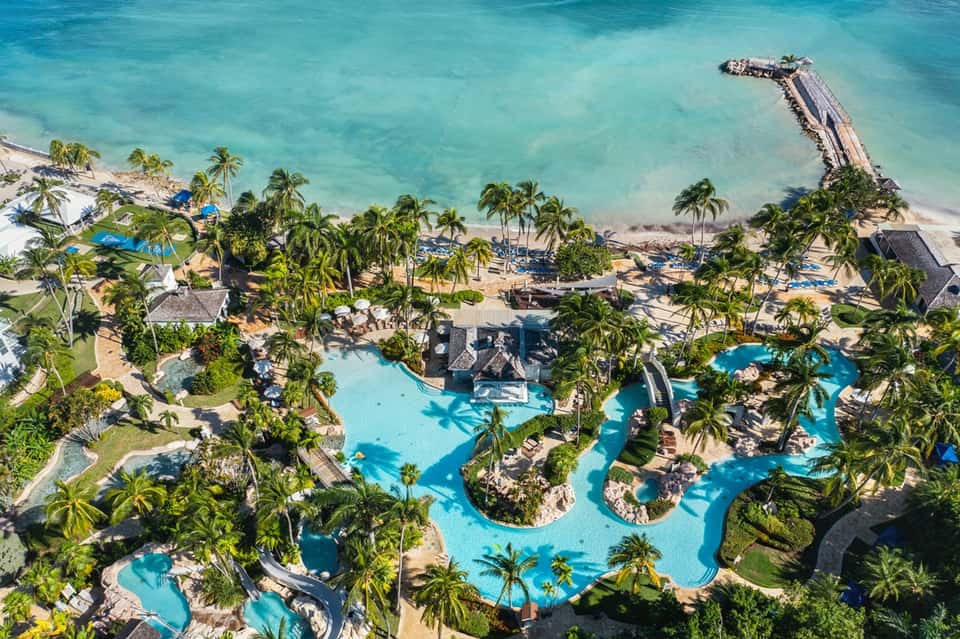 Aerial resort view with turquoise pools, palm trees and pristine beach