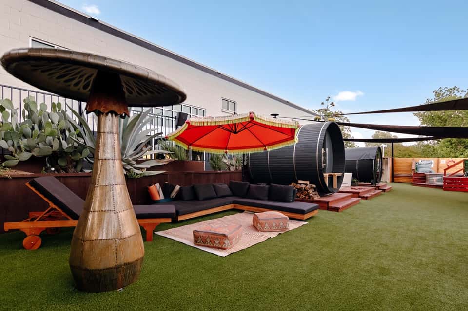 Outdoor lounge space with red umbrellas and modern sculptural elements