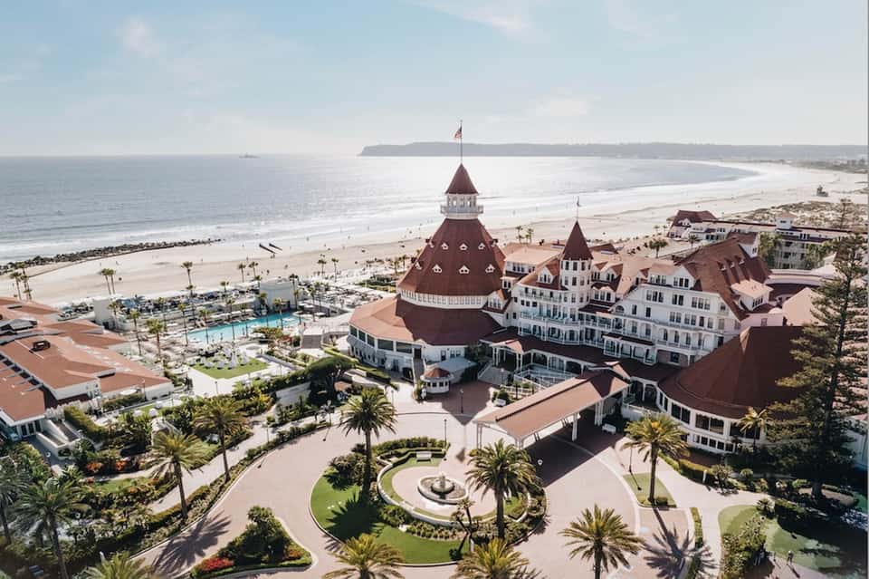 Beachfront hotel resort with distinctive red-roofed turrets overlooking sandy beach and ocean