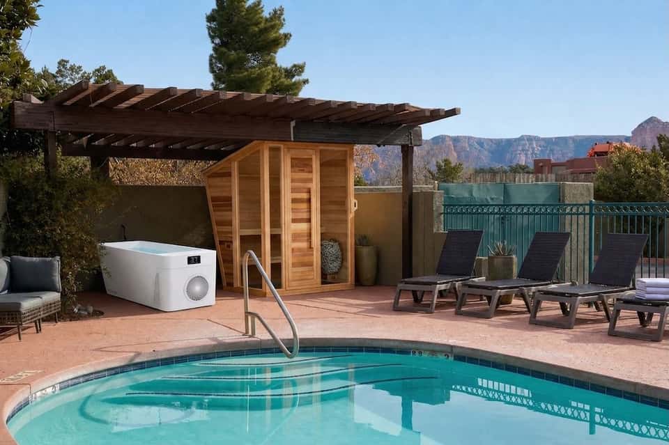 Resort poolside with sauna, lounge chairs, pergola, mountains views, and pool equipment