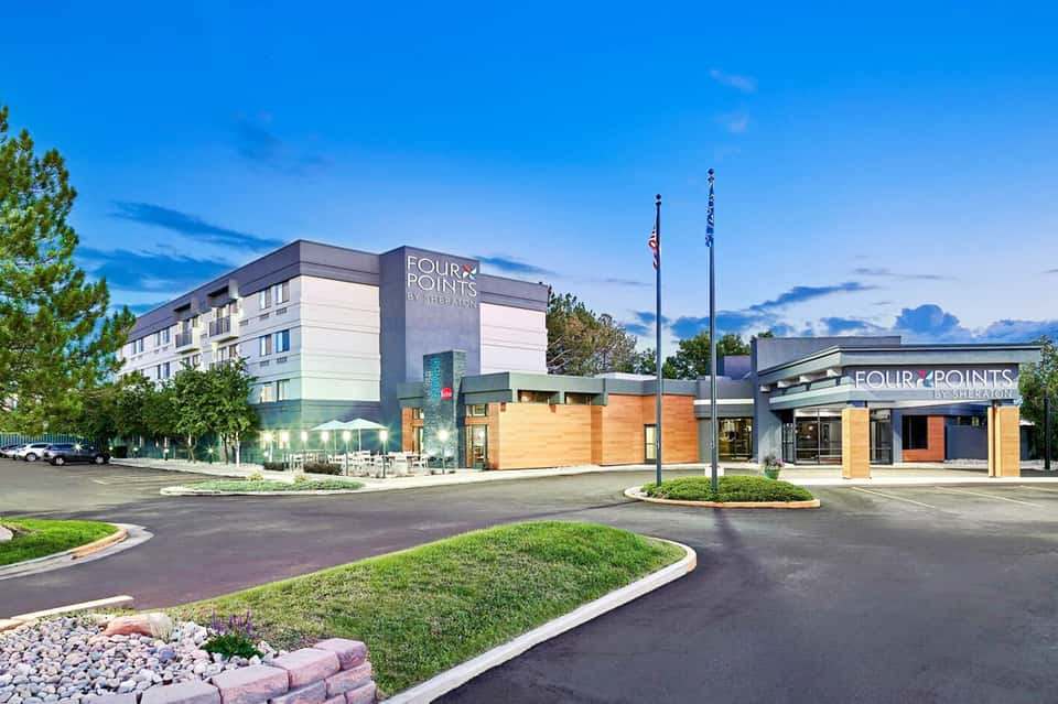 Four Points by Sheraton hotel exterior with modern architecture, manicured landscaping, and clear blue sky