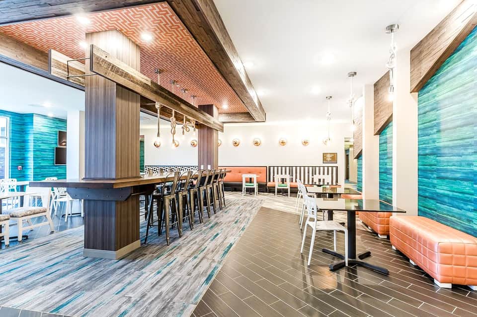 Modern restaurant and bar interior with wood accents, blue tile walls, and contemporary seating