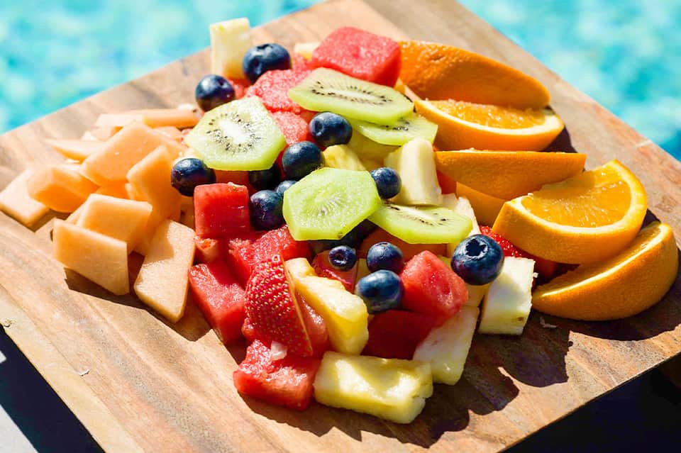 Colorful tropical fruit platter with cantaloupe, strawberries, kiwi, blueberries, and orange slices