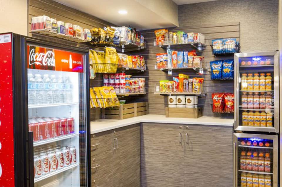 Convenience store interior with stocked shelves, beverages, snacks, and Coca-Cola refrigerator