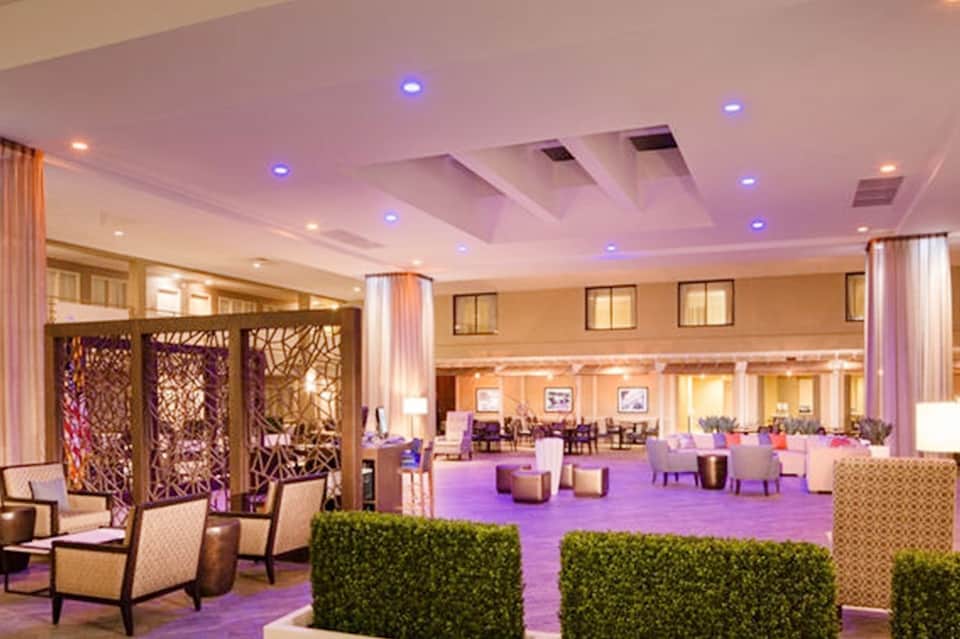 Luxurious hotel lobby lounge with purple ambient lighting, modern furniture, and elegant decor