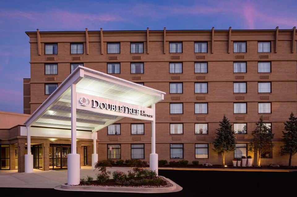 DoubleTree hotel exterior at dusk with illuminated entrance canopy and brick facade