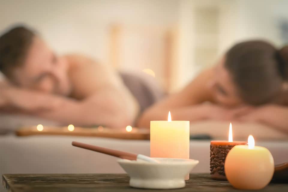 Spa massage treatment with lit candles and aromatherapy setup during relaxation session