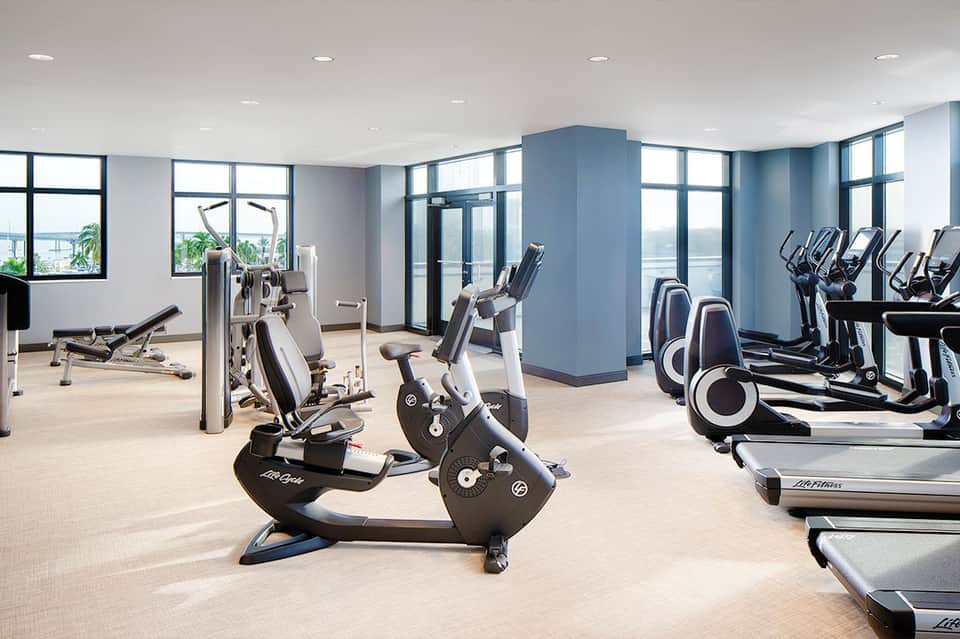 Modern gym facility with stationary bikes, treadmills, and exercise equipment with ocean views