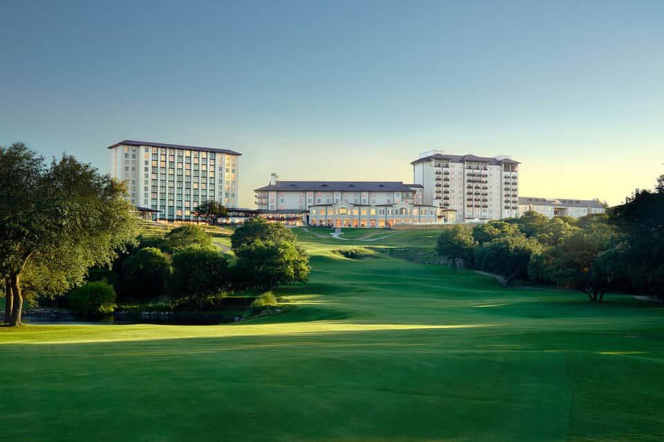 Golf course with hotel buildings and manicured lawns at golden hour