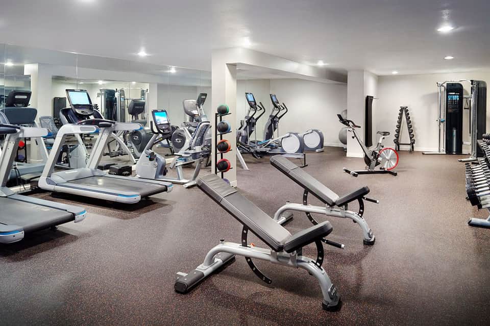 State-of-the-art fitness center with cardio equipment, weights, and mirrored walls