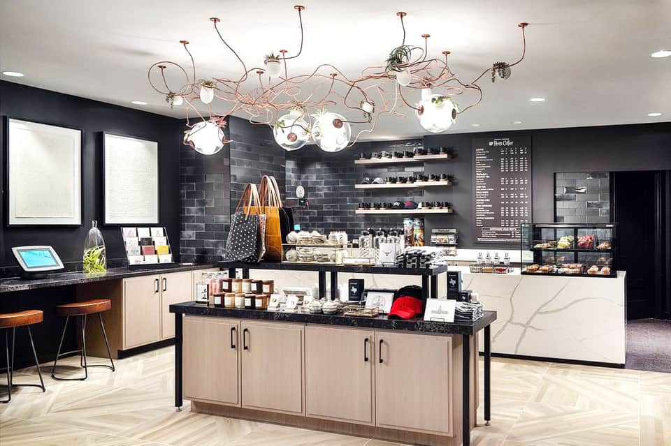 Contemporary salon or spa reception area with black walls, artistic copper lighting, and product displays