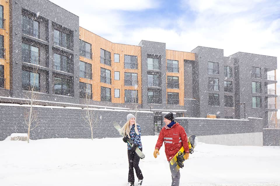 Modern apartment buildings with mixed brick and stone facades in snowy winter landscape