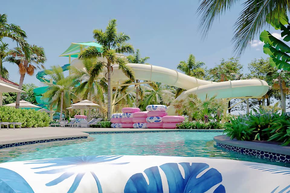 Resort pool with water slides, tropical palm trees, and pink inflatable floats