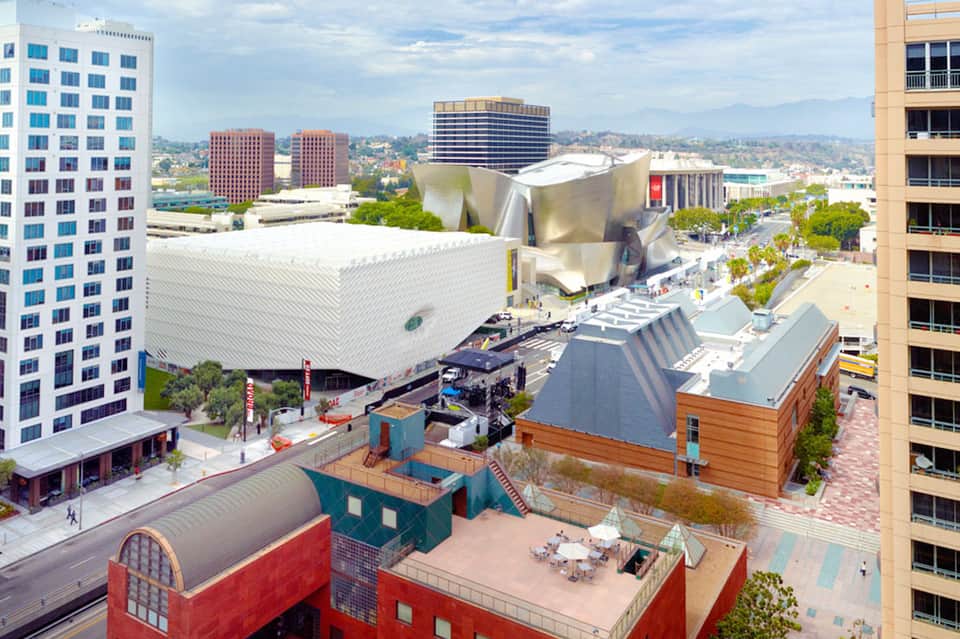 Aerial view of urban resort with modern architecture, distinctive white building, and rooftop amenities