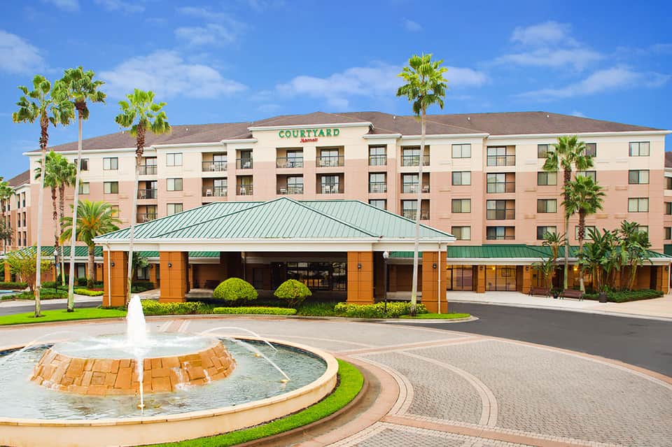 Courtyard Marriott hotel entrance with palm trees and decorative fountain