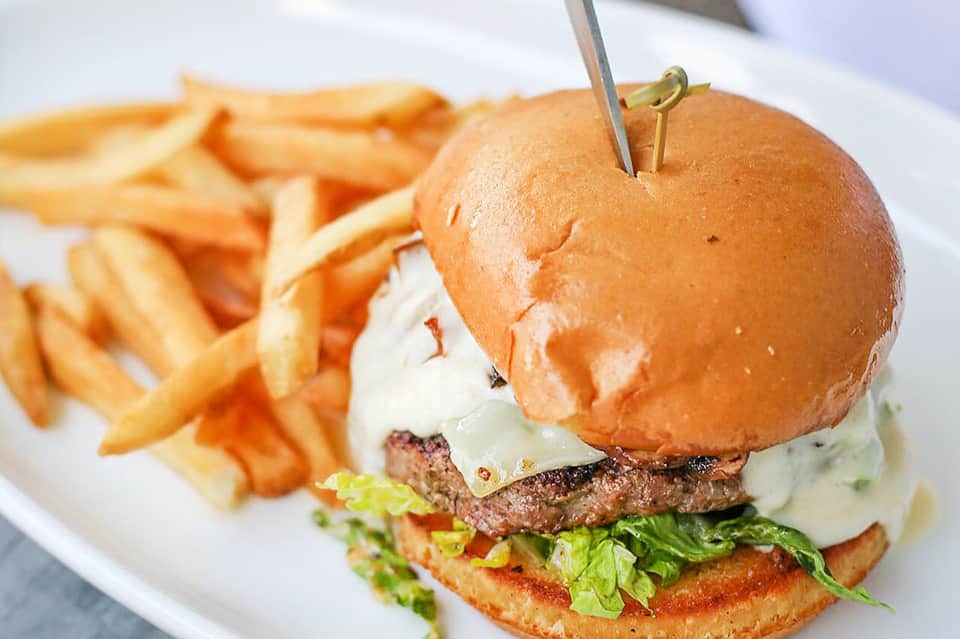 Gourmet burger with melted cheese and fresh lettuce served with crispy french fries