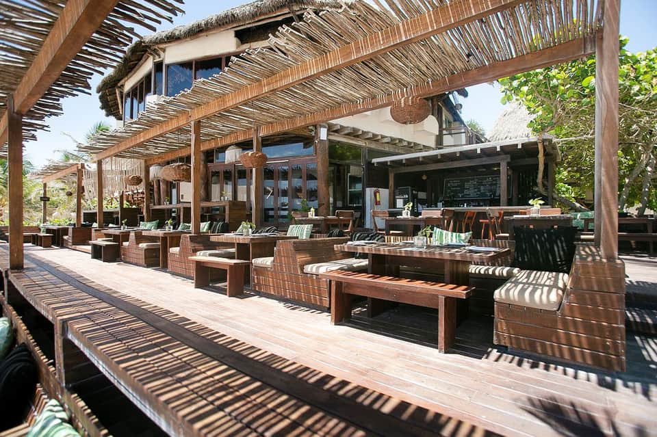 Wooden pergola outdoor dining area with wicker furniture and ocean views