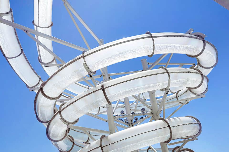 White water slides spiraling down against clear blue sky at an outdoor water park
