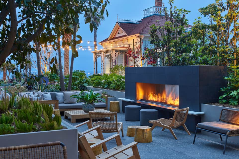 Luxury outdoor lounge area with fireplace, seating, and historic building backdrop