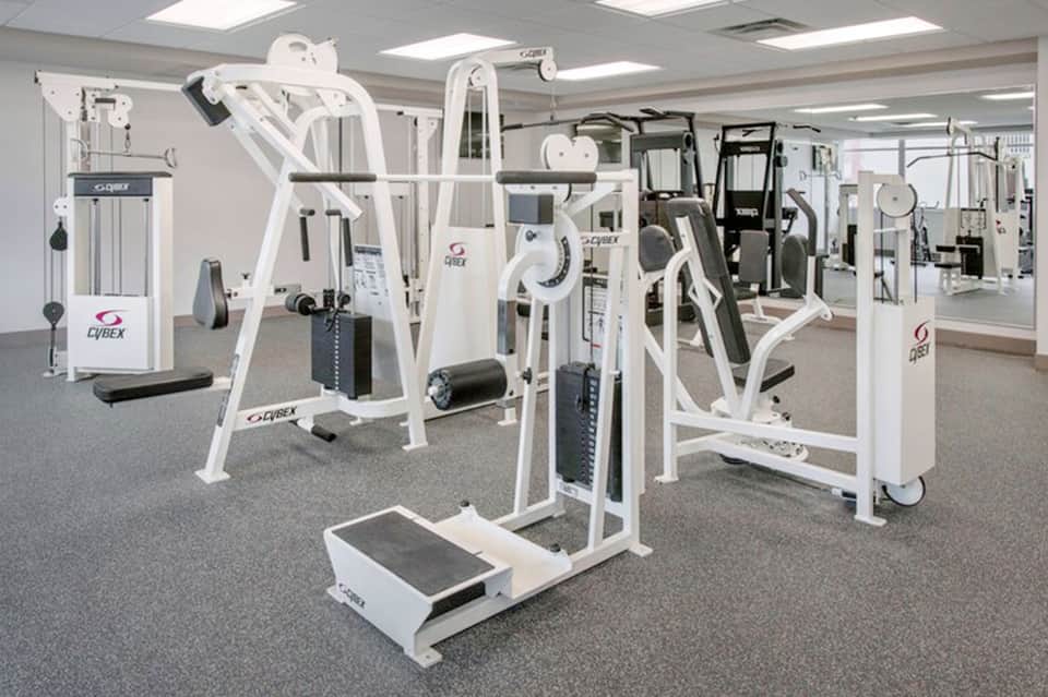 State-of-the-art fitness center with white Cybex exercise equipment and mirrored walls