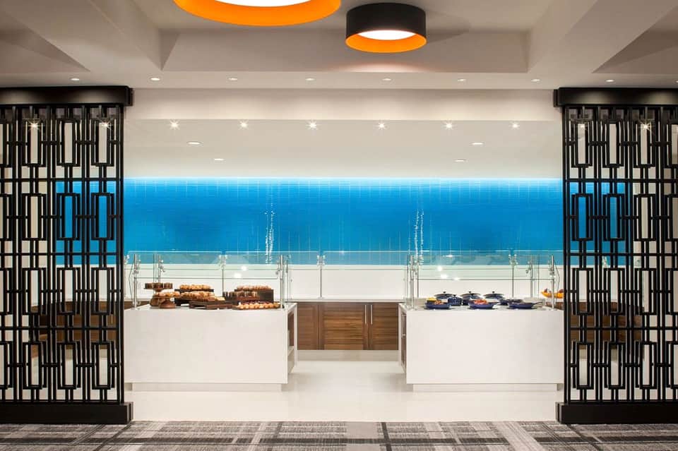 Modern bakery display case with ocean-view windows, featuring baked goods and pastries