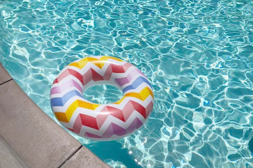 Colorful striped pool float in crystal-clear turquoise swimming pool water