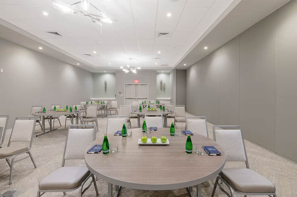 Conference room with round tables set up for business meetings with green bottles