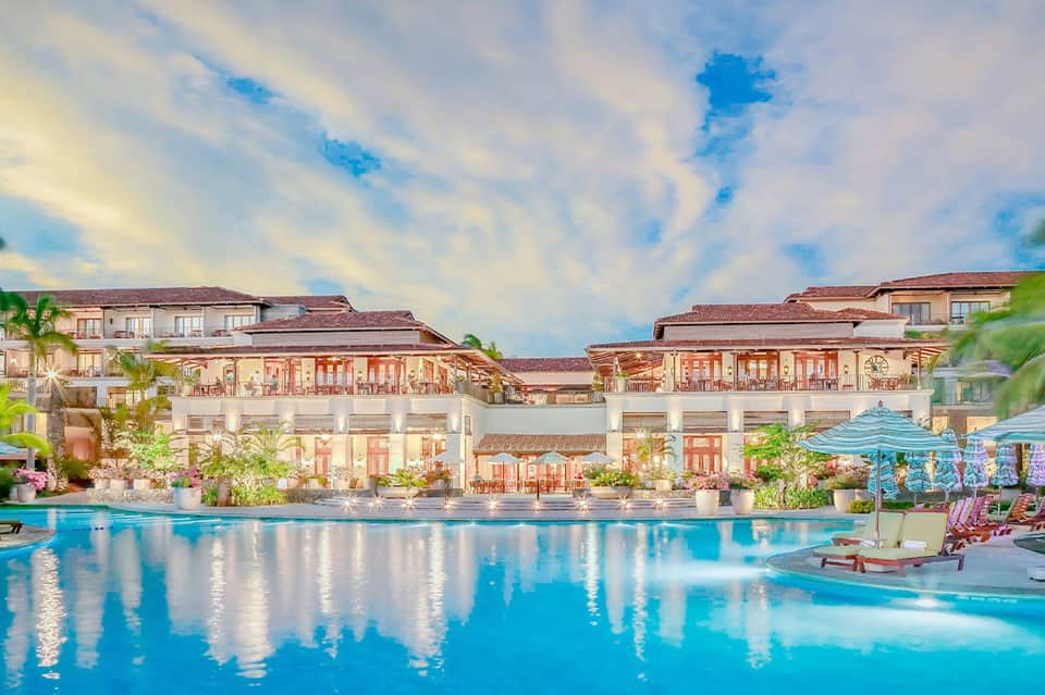 Luxury resort with Mediterranean architecture reflected in large swimming pool