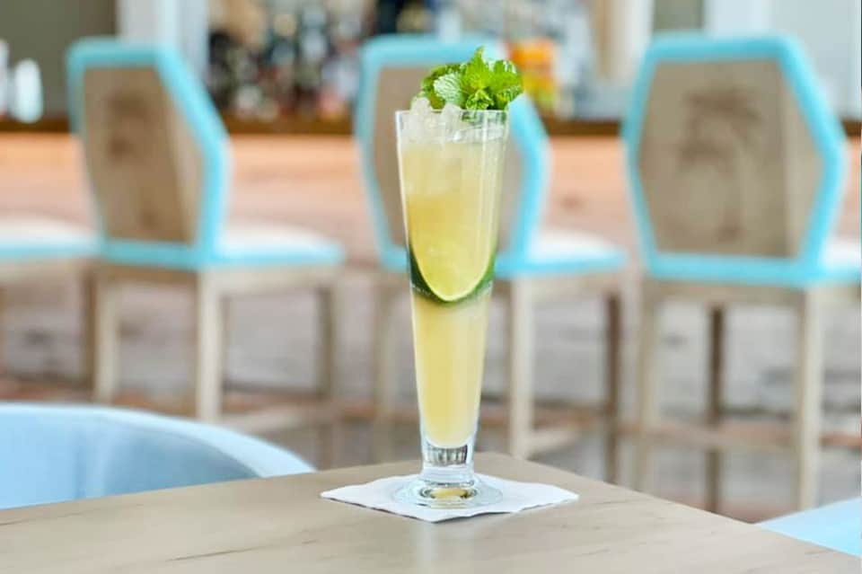 Refreshing mojito cocktail with lime and mint on outdoor resort table