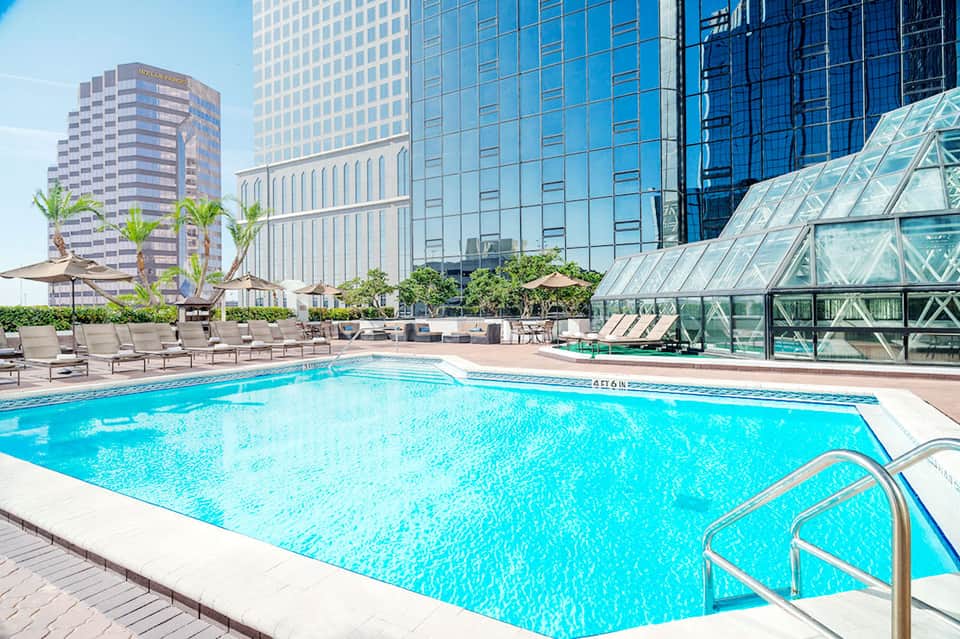 Urban rooftop pool with high-rise buildings and lounge chairs