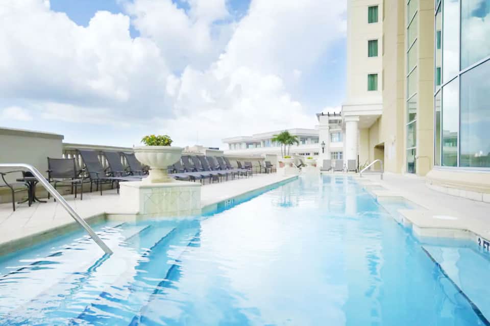 Rooftop indoor swimming pool with lane markings overlooking city buildings