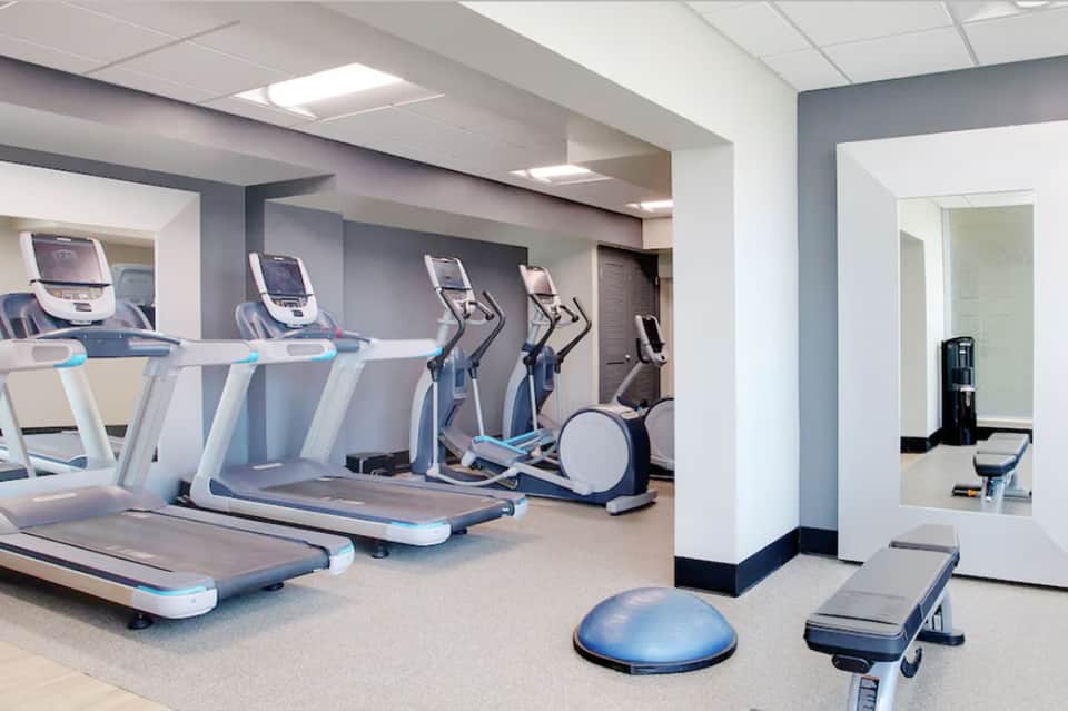 Modern hotel fitness center with treadmills, elliptical machines, and exercise equipment