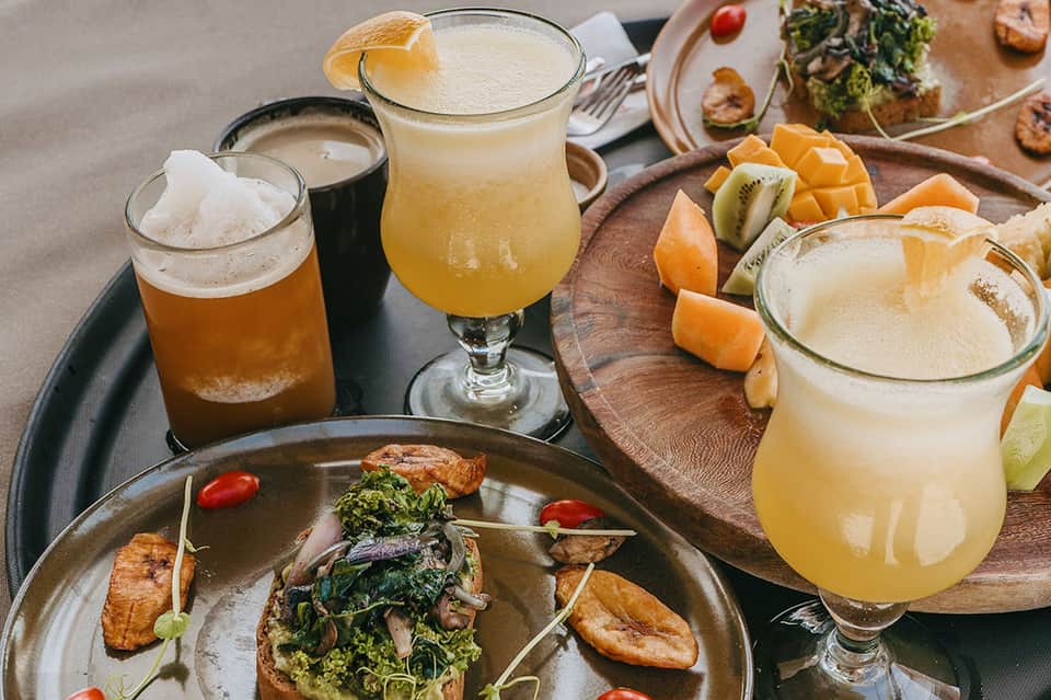 Gourmet cocktails and craft beers displayed with appetizers on wooden board at resort bar