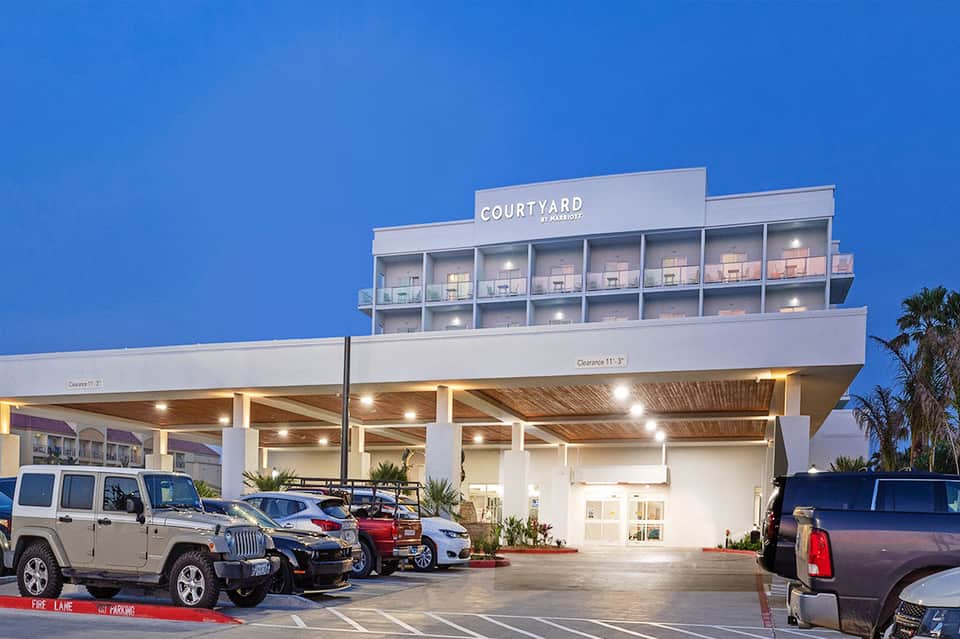 Courtyard by Marriott hotel exterior at dusk with modern architecture and parked vehicles