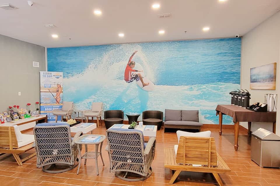Modern lobby lounge with surfing mural, comfortable seating, and coffee bar