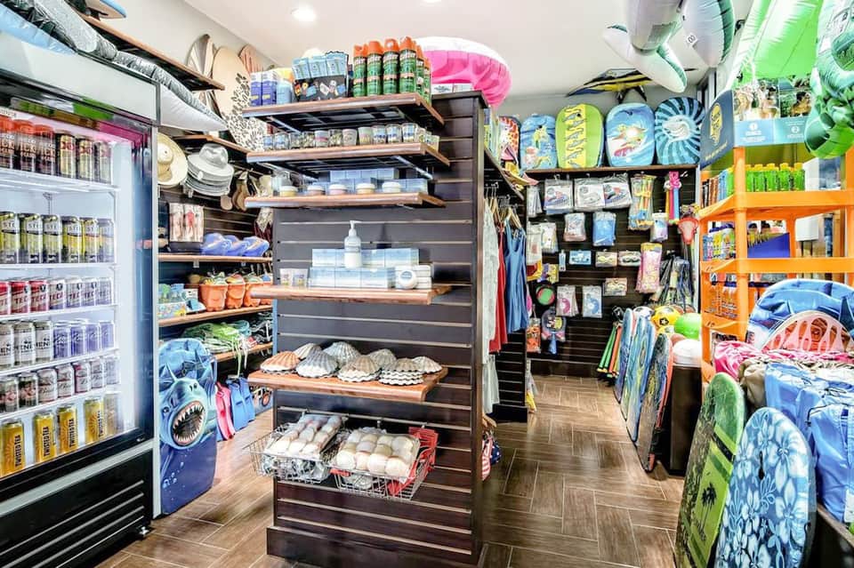 Beach resort shop interior with colorful shelving displaying vacation supplies and merchandise
