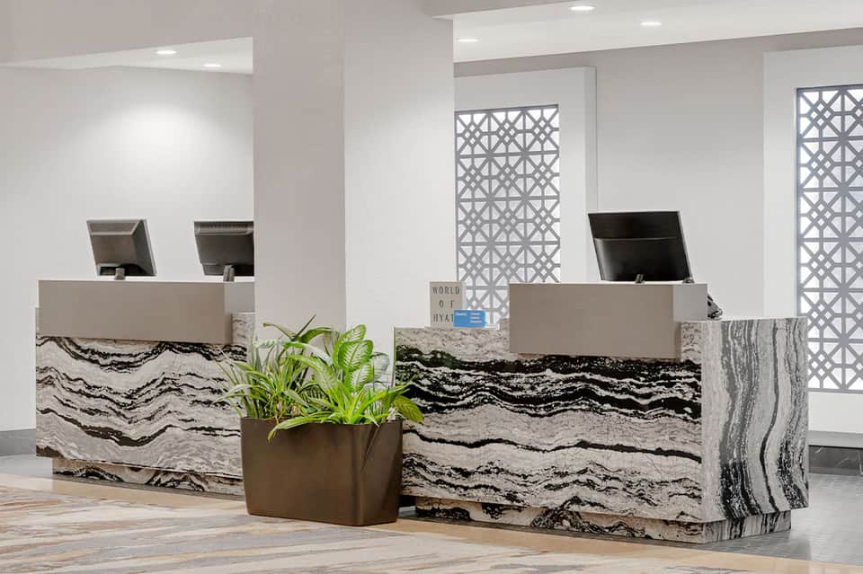 Hotel check-in desk with marble wave pattern and modern geometric wall panels