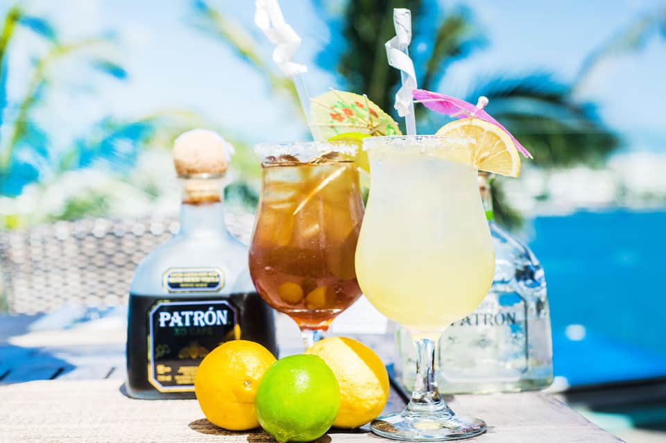 Tropical beach cocktails with Patron tequila, lime, and decorated with colorful umbrellas