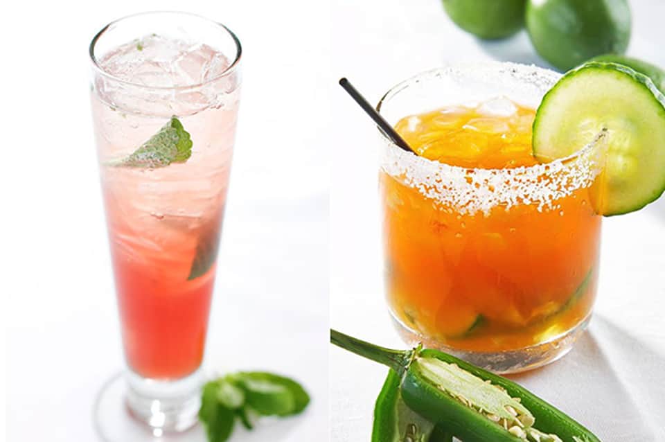 Two tropical cocktails: a pink drink with mint and ice, and an orange margarita with salt rim and cucumber slice