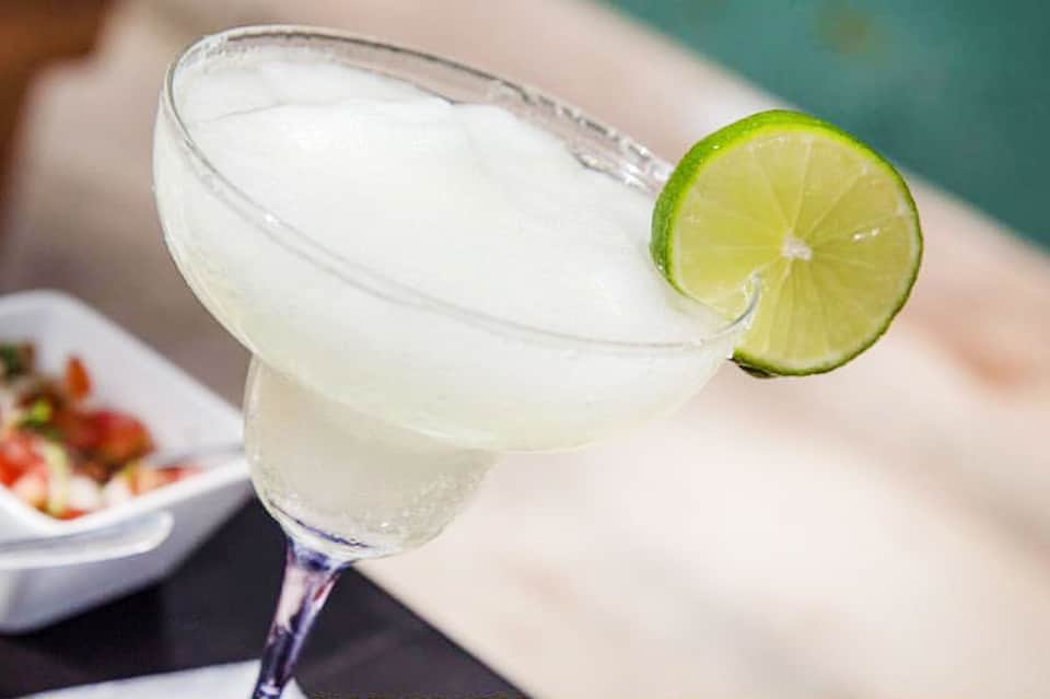 Margarita cocktail with lime wheel garnish and salted rim