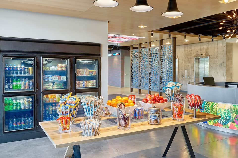 Modern hotel market with refrigerated beverage cases, snacks, and fresh fruit display
