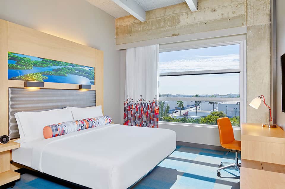 Modern hotel bedroom with water views and contemporary furnishings