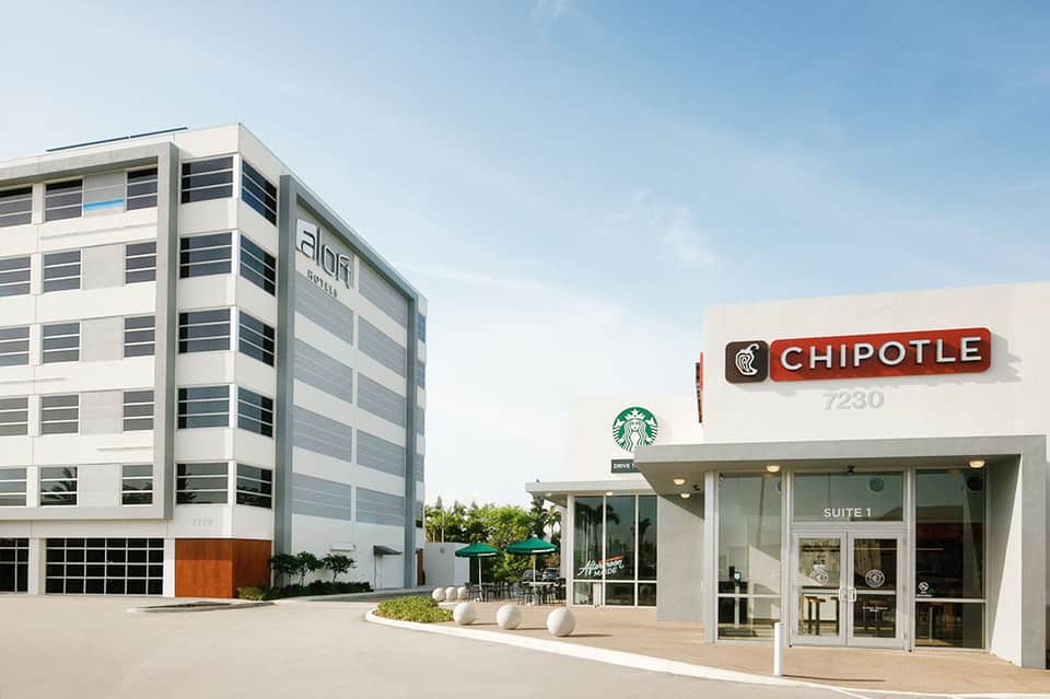 Contemporary office building with Chipotle and Starbucks storefronts on ground level