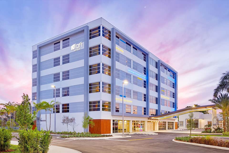 Modern aloft hotel building at dusk with illuminated windows and contemporary architecture