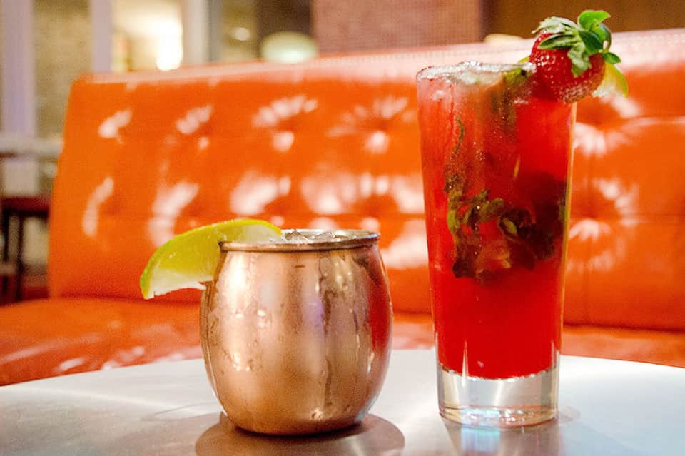 Tropical cocktails on table with orange sofa in background